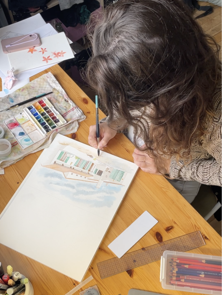 Illustratrice freelance à son bureau en train de travailler sur des illustrations artistiques à l'aquarelle